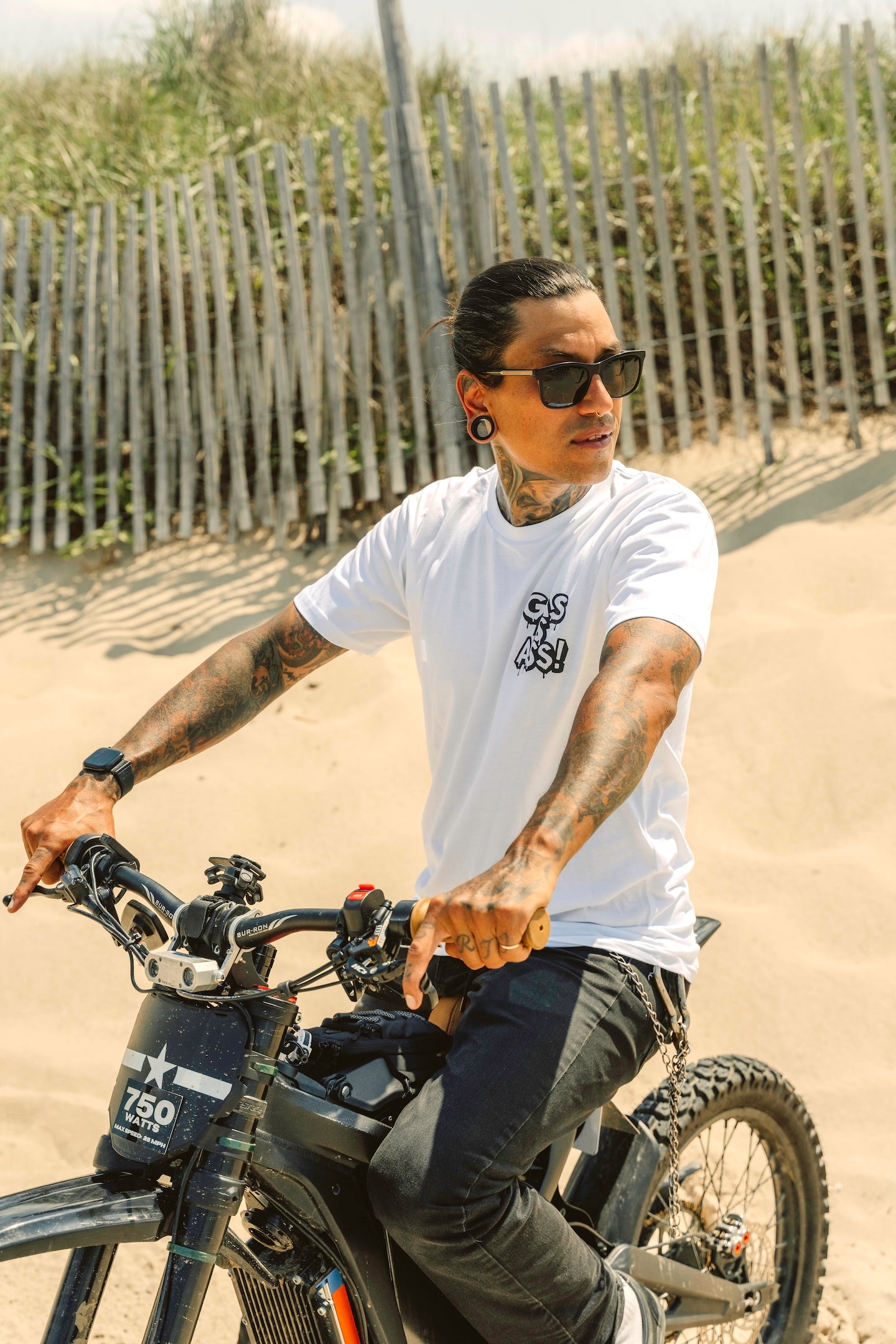 Gas Is Ass shirt white with tattoo print front view with person riding an electric dirt bike in the sand