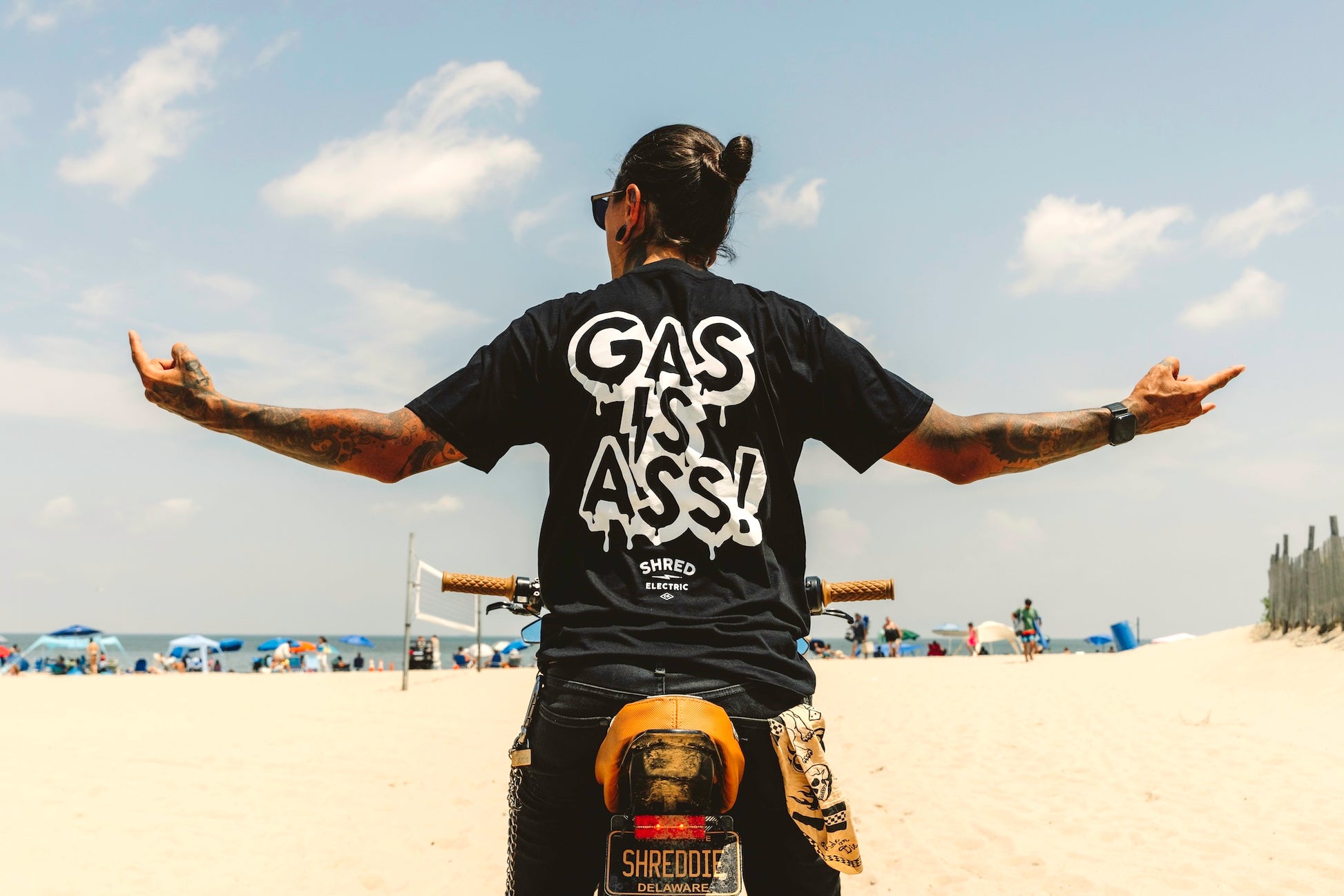 Gas Is Ass black t-shirt back view hands stretched on bike